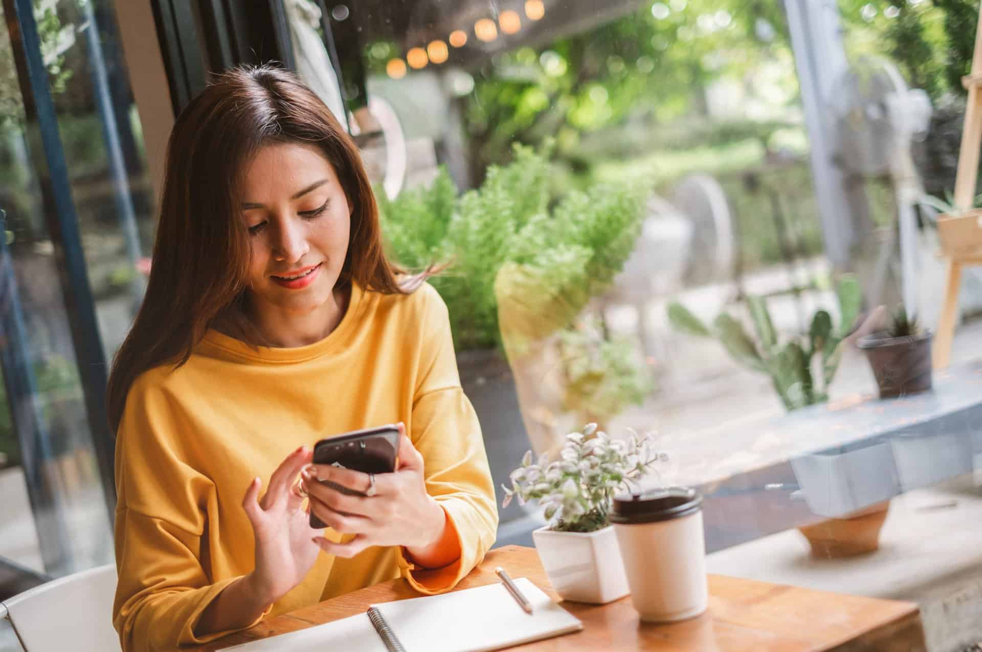 A woman using her phone in a café.