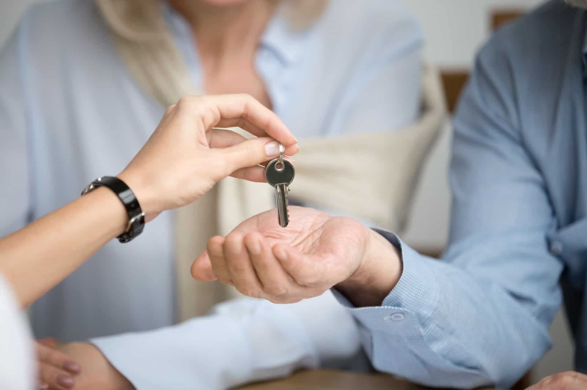 A couple receiving keys from an estate agent.