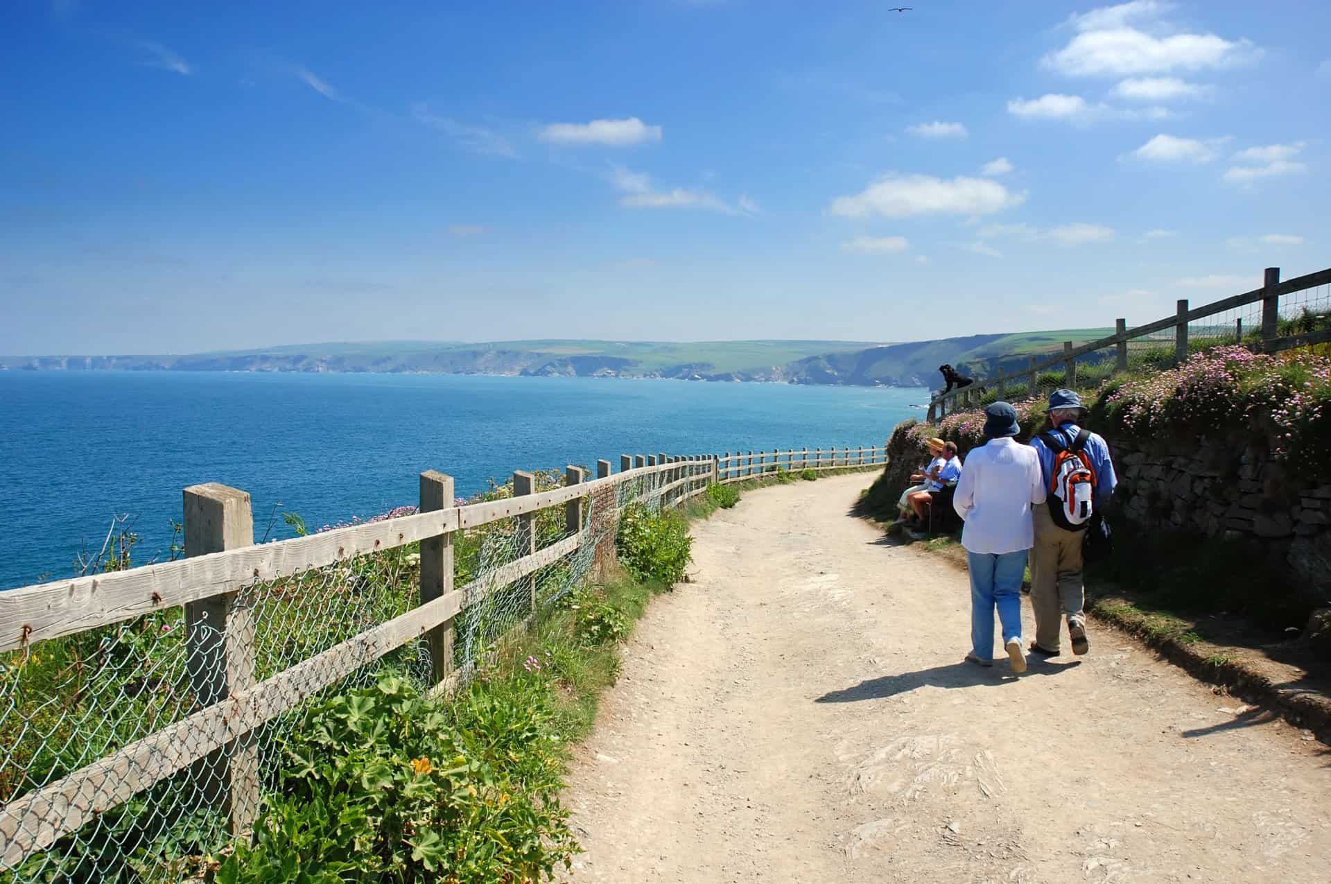 Two people walking along the coast in Port Isaac, Cornwall