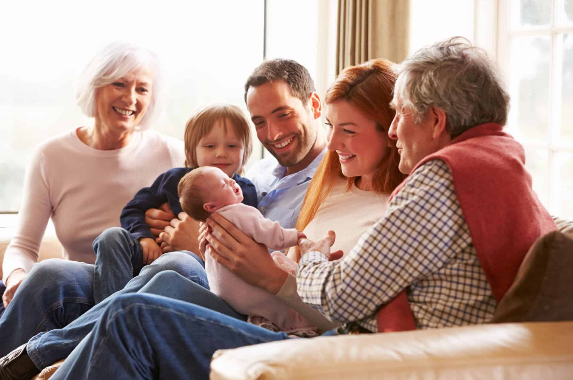 A multi-generational family sitting on the sofa.