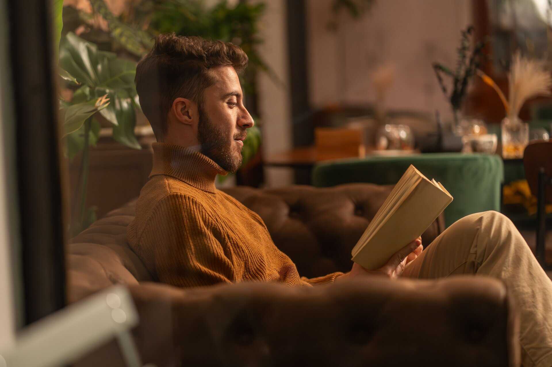 A man reading a book at home.