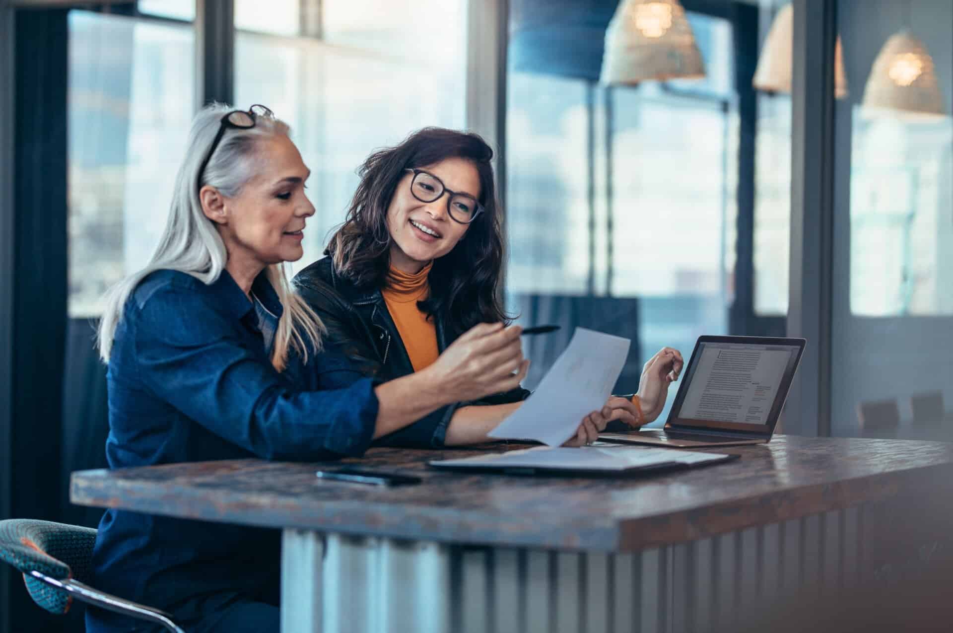A woman talking to a colleague in an office.